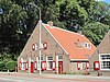 Karakteristiek huis van begane-grond met hoog zadeldak tussen puntgevels met vlechtingen