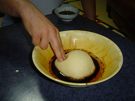 Libyan asida served with rub and molten sheep ghee; the traditional way to eat Libyan asida is to do so using the index and middle fingers of the right hand.