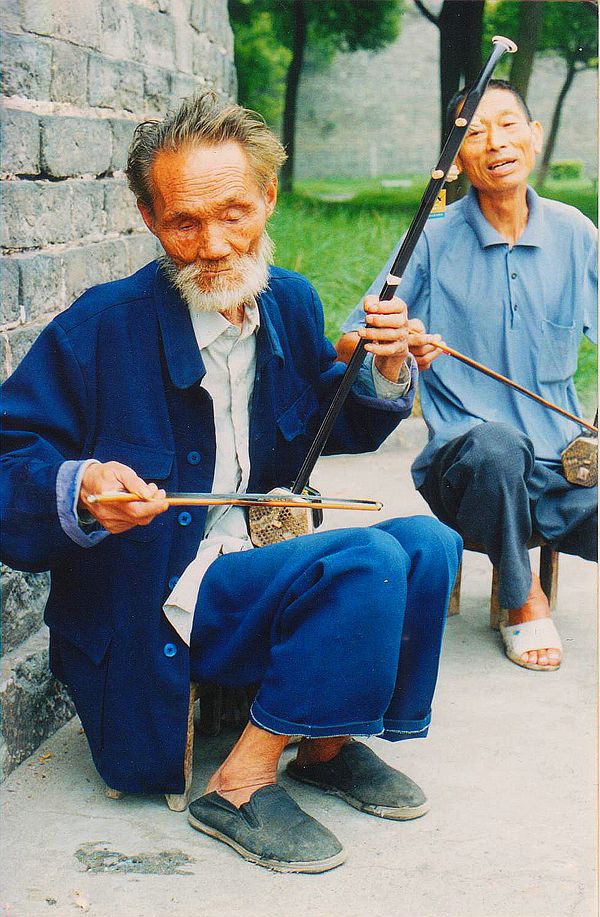 Two performers playing the Erhu, sometimes known as the Chinese fiddle.