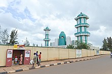 Photographie de la mosquée depuis la rue, avec un petit magasin local visible au premier plan