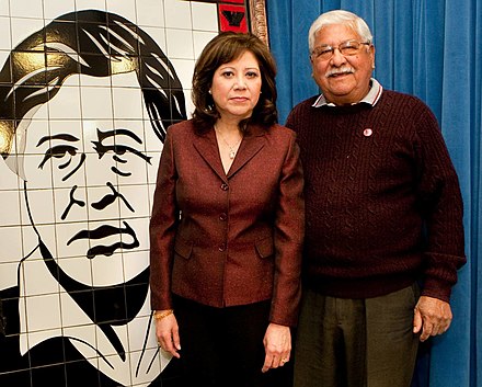 Secretary Solis with farm worker organizer Richard Chavez in 2010, next to a mural depicting his brother César Chávez