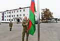 Ilham Alijev vztyčuje 16.11.2020 ázerbájdžánskou vlajku nad troskami města