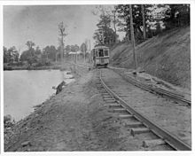 A streetcar travels beside the Thames River in downtown London, Ontario, in 1894 London Street Railway, Streetcar on the Springbank Line behind Woodland Cemetery, London, Ontario.jpg