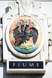 Wappen von Fiume auf dem einst von der Marinesektion des k.u.k. Kriegsministeriums genutzten Amtsgebäude Marxergasse 2 in Wien. Im amtlichen Gebrauch der k.u.k. Marine wurden die Namen in italienischer Sprache verwendet.