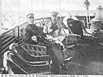 Kung Oscar II och kronprins Gustaf inväntar den tyske kejsaren Vilhelm II ombord på Drott i Gävle den 14 juli 1905. Kronprinsen är av denna anledning iförd tysk uniform.