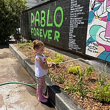 Young gardener waters at the Pablo Forever mural and garden planting at Washington Park Skatepark. Pablo Forever Garden.jpg