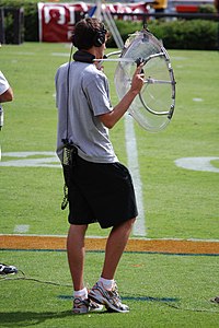 Parabolic microphone with optically transparent plastic reflector used at an American college football game.