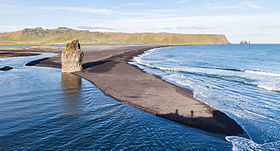 Reynisfjall widziany z Dyrhólaey na zachodzie z Arnardrangurem na pierwszym planie i Reynisdrangar po prawej stronie.