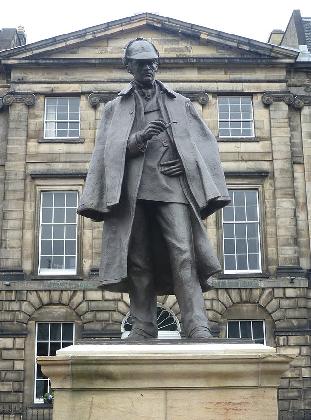 A statue of Sherlock Holmes holding a pipe outside a building