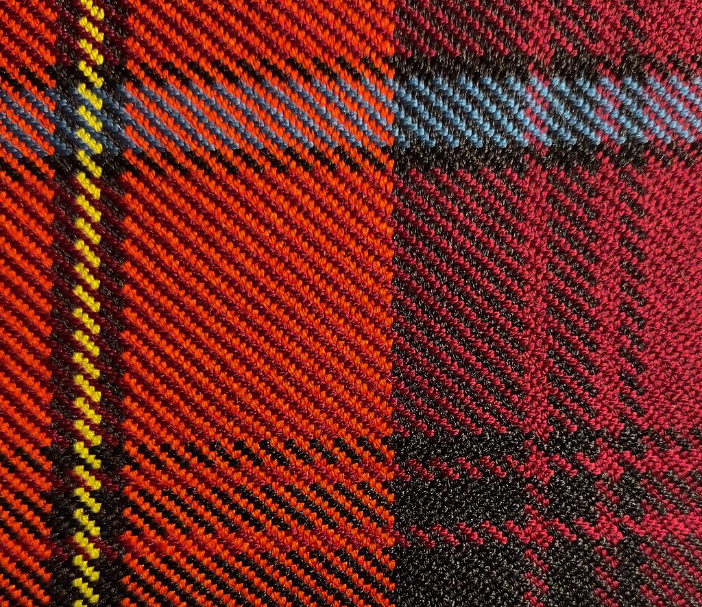 Close-up view of scarlet red, black, yellow, azure bleu, and crimson red tartan cloth