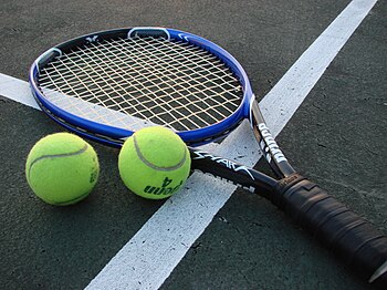 Shot of a tennis racket and two tennis balls o...