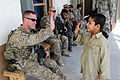 U.S. Army Staff Sgt. Joshua W. Ginn, medic, Regional Command - South (RC-S) protective service detail, 82nd Airborne Division, high-fives an Afghan boy during a mission, in Kandahar province, Afghanistan 111102-A-EK646-007.jpg