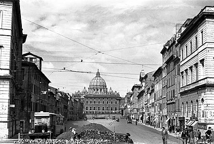 The palace (centre), photographed during its demolition in 1937, is dominated by the massive dome of St. Peter's behind it