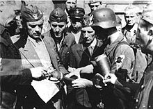 Cyprian Odorkiewicz commander of "Krybar" Regiment (second from left) inspects ammunition for PIAT anti-tank weapon belonging to "Rafalki" unit during Warsaw Uprising 1944 Warsaw Uprising - Cyprian Odorkiewicz and Rafalki.jpg