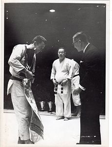 Mikinosuke Kawaishi, 10e dan (jū-dan, ceinture rouge). Au centre, en présence du champion d'Europe 1951, Jean de Herdt.