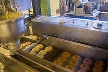 Photograph of doughnuts on a conveyer belt machine