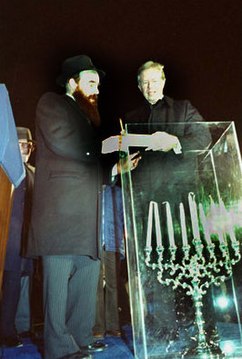 U.S. President Jimmy Carter (right) lighting a hanukkiah with rabbi Abraham Shemtov (left) in Lafayette Park, 1979