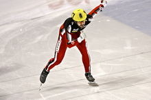 Charles Hamelin, en combinaison rouge, patine sur la glace.