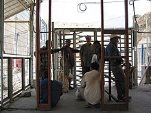 Palestinian workers wait at the Erez Crossing to enter the Gaza Strip, July 2005. ErezTurnstiles.jpg