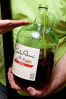 An open bottle of Carlo Rossi jug wine with a drinking straw. Jug wine.jpg
