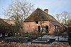 Boerderij van het Kempische langgeveltype, met rieten wolfdak met voet van pannen, met vrijstaande deels bakstenen, deels houten schuur onder rieten wolfdak. Een tweede schuur onder rieten wolfdak achter de boerderij