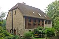 Residential house (with inscription plaque), two side buildings and manual pump of a farm