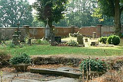 Pohled do prostoru kukského hřbitova. V popředí jsou patrné základy někdejší hřbitovní kaple a zajištěný vstup do někdejší hrobky.