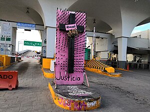 Ein Kreuz auf rosafarbenem Grund neben der Durchfahrt am Übergang zwischen den USA und Mexiko symbolisiert das Leid und die Gewalt, die Frauen angetan wurde.