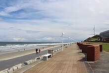 Steinernes Deckwerk als Promenade an der Nordseite der Insel im Jahr 2015 vor der Klinik Norderney an der Kaiserstraße. Zu erkennen sind die als Wellenbrecher eingesetzten Granitblöcke, die Schwallelemente (rechts) und das S-Profil (links) 53.7111417.143916