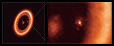 Das Bild besteht aus zwei Teilen. Links ist eine kreisförmige, orange leuchtende Struktur vor einem dunklen Hintergrund zu sehen, die einen kosmischen Staub- oder Gasring darstellt. Im Zentrum des Rings befindet sich ein kleiner, heller Punkt, der von einem unscharfen Bereich umgeben ist. Rechts sieht man eine vergrößerte Nahaufnahme dieses Zentrums, in der der helle Punkt und seine nähere Umgebung detaillierter sichtbar sind. Die rechte Bildhälfte zeigt eine diffuse, rötlich-orange Struktur mit einem klarer hervorgehobenen, hellen Punkt, vermutlich der zentrale Stern. Das Bild wurde mit dem ALMA-Teleskop aufgenommen und zeigt wahrscheinlich ein protoplanetares System, in dem Planeten um den Stern entstehen könnten.