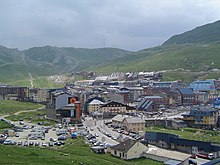 Vue d’un village commercial entouré de montagnes.