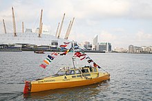 Lewis pedalling his boat Moksha on the River Thames in London, shortly before completing the first human-powered circumnavigation of the Earth (2007) Pedal Boat Moksha on River Thames.jpg