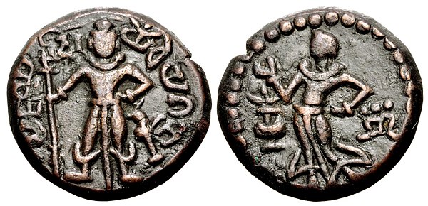 Yaudheya coin, imitative of Kushan coinage, 3rd-4th centuries CE. Obverse: Karttikeya standing facing, holding a spear with dvi (“two” in Brahmi) to t