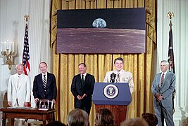 Photographie en couleur de l'équipage d'Apollo 11 lors d'un discours présidentiel.