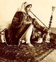 Kadžárská kurtizána kouří vodní dýmku, fotografie ruského fotografa Antona Sevrjugina, asi 1900