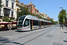 CAF ACR-equipped Urbos 3 tram running through central Seville, 2015. The tram is powered by supercapacitors charged by a ground-level power supply. Seville Metro Train.JPG