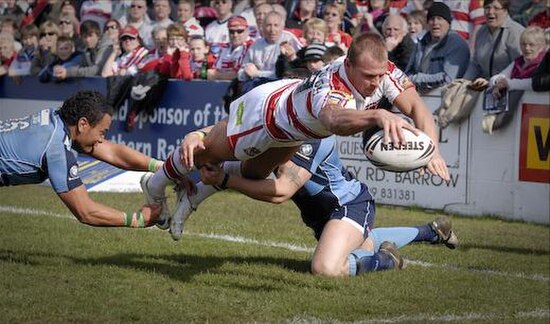 Barrow Raiders player, Zeb Luisi attempting to tackle Shaun Ainscough of Wigan