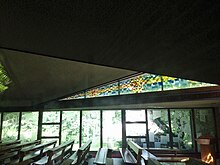 The original clear windows were designed to display the gardens outside as a work of God. They were later replaced with etched windows featuring Bible proverbs and images. St Edmunds Elm Grove Midcentury Modern interior.jpg