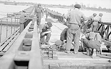 Sappers place the final planks of a Bailey pontoon bridge over the Rhine. The British Army in North-west Europe 1944-45- Class 40 Bridge Over the Rhine BU2483.jpg