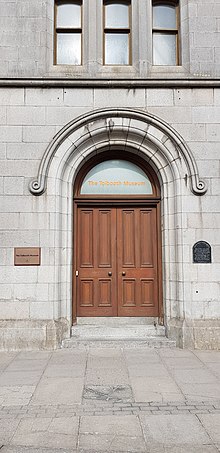 Zobrazuje přední dveře muzea Tollbooth