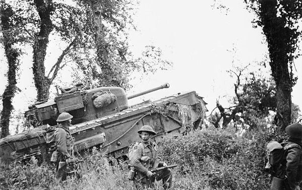 A Churchill tank of the 7th Royal Tank Regiment supporting infantry of the 8th Battalion, Royal Scots during Operation Epsom, 28 June 1944.