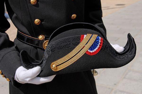 The full-dress uniform of École Polytechnique of France comprises black trousers with a red stripe, a coat with golden buttons and a belt, and a cocke