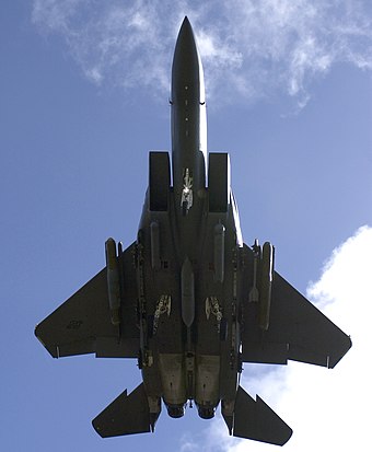 An underside view of an F-15E Strike Eagle with landing gear down