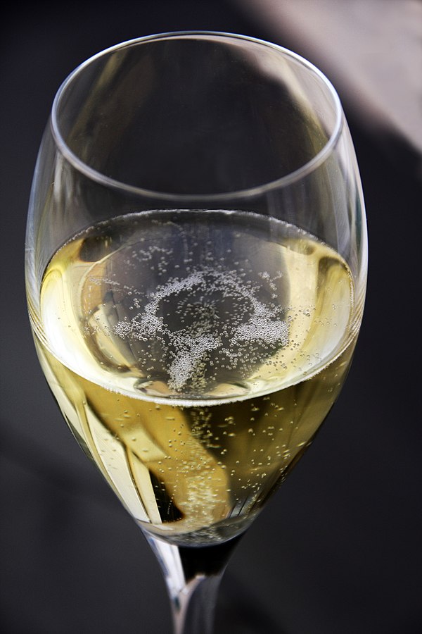 A glass of Champagne exhibiting the characteristic bubbles associated with the wine