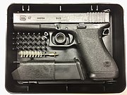 Le Glock 17 « première génération » de 1983, présenté avec ses accessoires dans sa boîte en plastique d'origine.