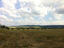 Kanstein aus nördlicher Richtung im Mittelgrund (heller Bereich). Dahinter der Harz. Davor das Tal der Innerste.