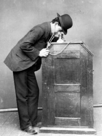 رجل يستعرض الصور المتحركة على جهاز الكينتوسكوب سنة 1895.