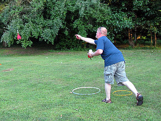 A man throwing lawn darts