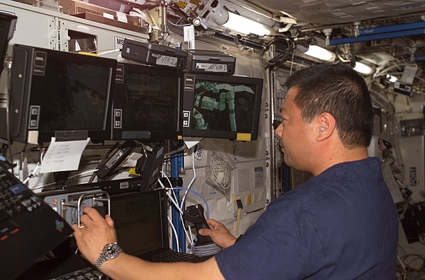 Astronaut Leroy Chiao works with the controls of the Canadarm2