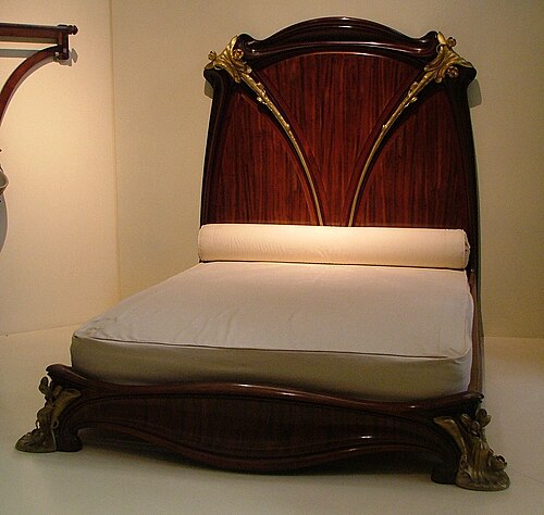 A mahogany bed, known as the Nénuphar bed for its water lily motifs, designed and manufactured by Louis Majorelle around 1902-3, on display at the Mus